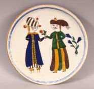 A TURKISH KUTAHYA POTTERY FIGURAL PLATE - decorated with figures and flora, 17.5cm