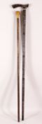 TWO WOODEN INDIAN WALKING STICKS - the larger with white metal and gilt inlaid decor, 93cm high, the