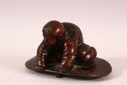 A CHINESE BRONZE FIGURE OF A BOY PLAYING - the boy knelt upon a play mat, 10cm