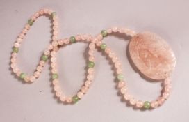 A CHINESE ROSE QUARTZ CARVED NECKLACE / PENDANT - with a carved pendant with beads, 74cm approx.