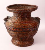 A JAPANESE MEIJI PERIOD WOVEN IKEBANA BASKET VASE - the woven basket with twin handles and a