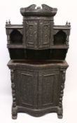 A SUPERB CEYLONESE CARVED EBONY CABINET, with broken arch pediment above a pair of bow fronted doors