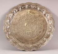 A SRI LANKAN POSSIBLY SILVER DISH, with embossed and chased decoration, 35cm diameter.