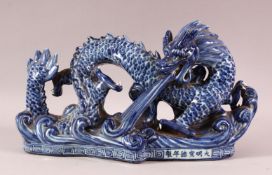 A CHINESE BLUE & WHITE PORCELAIN MODEL OF A SEA DRAGON, depicted rising from the ocean, the front