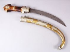 A LARGE SAUDI ARABIA JAMBIYA DAGGER, With a carved wooden handle, metal mounted sheath, 64cm long.
