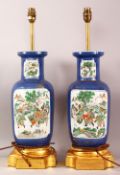 A PAIR OF CHINESE FAMILLE VERTE PORCELAIN VASES AS LAMPS, with panel decoration upon a blue gilt