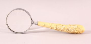 A 19TH CENTURY CARVED IVORY MAGNIFYING GLASS, carved with native floral scroll. 25cm