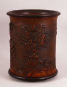 A CHINESE BAMBOO CARVED BRUSH POT - decorated with village landscape scenes, 15cm diameter