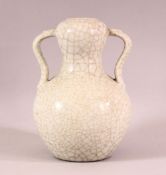 A CHINESE CRACKLE GLAZED PORCELAIN TWIN HANDLE VASE, the base with gilt calligraphy, 19cm high