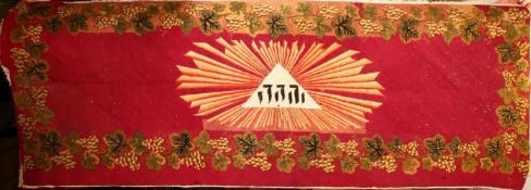 A LARGE JEWISH TAPESTRY RUG / RUNNER, the centre with a judaica script, with grape and vine borders,
