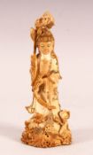 A CHINESE CARVED & POLYCHROME DECORATED IVORY FIGURE OF GUANYIN - stood holding flora and surrounded