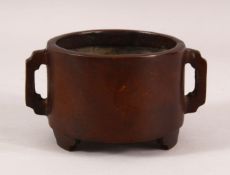 A CHINESE TWIN HANDLE BRONZE BRUSH WASH / CENSER, with twin handles and tripod feet, 14cm diameter
