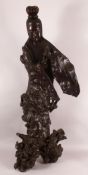 A LARGE 18TH CENTURY CHINESE ROOT WOOD CARVING OF GUANYIN, on a naturalistic root base, 101cm high.