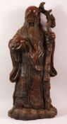 A LARGE CHINESE BRONZE STATUE OF A SAGE holding a peach in one hand and a staff in his other hand,