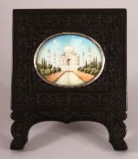 A SMALL INDIAN / CEYLONESE EBONY FRAME WITH IVORY PAINTED SCENE - the painting depicting the taj-