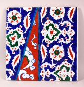A TURKISH IZNIK STYLE POTTERY TILE - decorated with floral motif decorations, 28cm