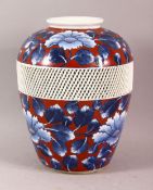 A JAPANESE BLUE AND RED PORCELAIN VASE, the body with a reticulated band around the centre and
