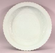 A LARGE CHINESE CELADON CARVED CHARGER - the charger carved with scenes of birds and flora with a