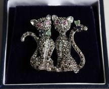A SILVER MARCASITE RUBY ENAMEL AND SAPPHIRE DOUBLE CAT BROOCH