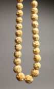 A CARVED IVORY GRADUATED BEAD NECKLACE on fifty eight beads 26ins long