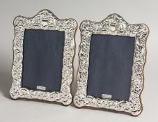 A PAIR OF SILVER PHOTOGRAPH FRAMES in Roccoco style 9ins x 5.5ins