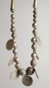 AN ISLAMIC SILVER NECKLACE with seven coins.