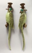 A PAIR OF ORNATE PORCELAIN AND ORMOLU WALL LIGHTS modelled as parrots seated on a tree stump.