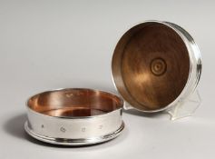 A PAIR OF MODERN PLAIN SILVER WINE WINE COASTERS wit turned wood bases 4.75diameter London 2003