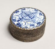 A CHINESE SILVERED CIRCULAR BOX AND COVER, blue and white porcelain top. 2.5ins diameter.
