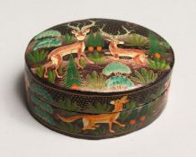 AN OVAL LACQUER BOX painted with deer 3.5ins