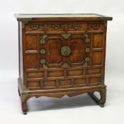 A 19TH CENTURY KOREAN ELM SIDE CABINET, with four small drawers over a pair of panelled doors on