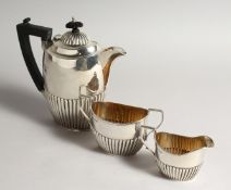 A THREE PIECE SEMI FLUTED TEA SET comprising tea pot, sugar basin and milk jug Birmingham 1915.