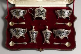 A VERY GOOD SET OF VICTORIAN SILVER CRUETS, comprising four salts and shell spoons, mustard pot