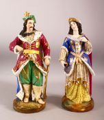 A PAIR OF TURKISH PORCELAIN SULTAN & SULTANA - both in traditional gowns holding objects, 38cm