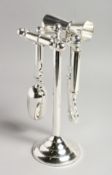 A PLATED FOUR PIECE BAR TOOL SET ON A STAND. 10ins high.