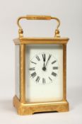 A GILT BRASS CARRIAGE CLOCK, with white enamel dial, roman numerals, the movement striking on a