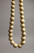 A GOOD GRADUATED IVORY BEAD NECKLACE on thirty five beads 16ins long