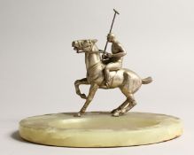 AN ONYX OVAL SHAPED DESK STAND, moulded with a model of a polo player on horseback 8ins wide.
