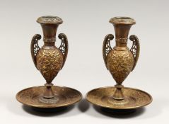 A PAIR OF ORNATE LATE 19TH CENTURY ITALIAN BRONZE URN SHAPED CANDLESTICKS, on circular bases, cast