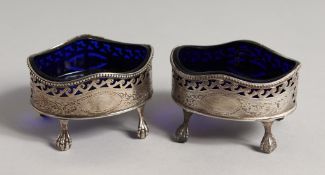 A PAIR OF GEORGE III OVAL SILVER PIERCED ENGRAVED SALTS with a sapphire blue liner on claw and