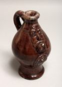A SMALL TIN GLAZED POTTERY BELLAMINE JUG with seal mark to base. 7.25ins high.