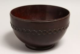 A GEORGIAN TURNED AND CARVED MAHOGANY CIRCULAR BOWL 8.5ins diameter 5ins high.