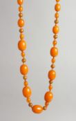 AN AMBER TYPE BEAD NECKLACE with seven large beads and numerous small beads.