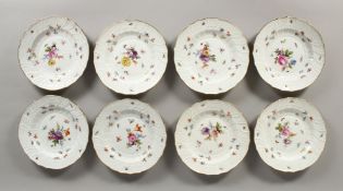 A SET OF EIGHT MEISSEN PORCELAIN DISHES with moulded gilt edged rim, each painted with flowers and