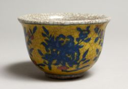 A CHINESE CRACKLEGLAZE TEA BOWL, yellow ground painted with fruit 3.5ins diameter.