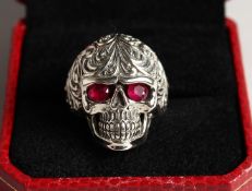 A SILVER SKULL RING with ruby eyes