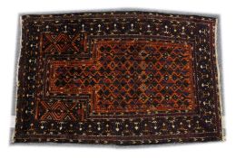 A BELUCHI PRAYER RUG, rust ground with stylised geometric design 5ft x 3ft 5ins