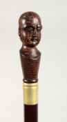 A WALKING STICK, the handle modelled as a phrenology head. 36ins long.