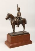 A BRONZE OVERLAID COMPOSITE MODEL OF A HUSSAR ON HORSEBACK, on a wooden plinth base 17ins high.