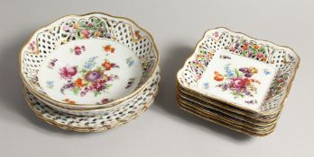 A CONTINENTAL PORCELAIN PIERCED DESSERT SET painted with flowers comprising circular dishes, 9ins
